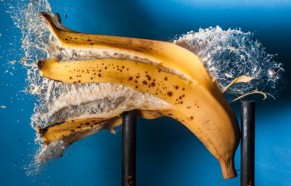 Still shot of a banana exploding after being shot with a ball bearing